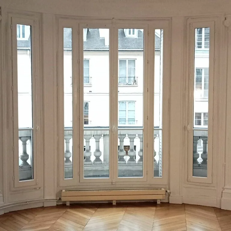 Grandes fenêtres et porte-fenêtre ouvrant sur un balcon à balustres